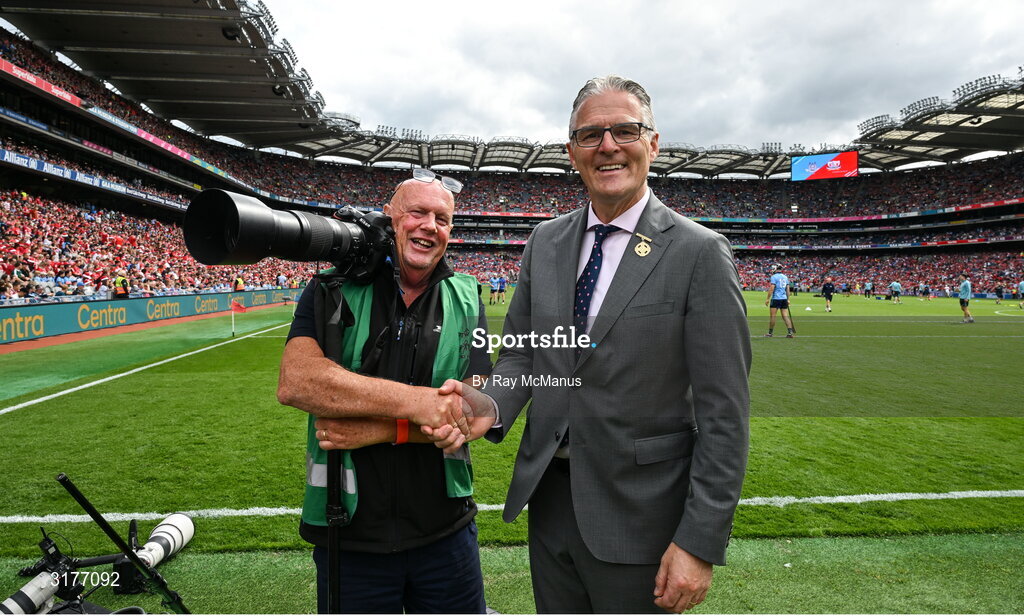 5 July 2025; Irish Examiner photographer Eddie O'Hare, who retired after today's game having served the paper for more than 47 years, is photographed with the Uachtarán Chumann Lúthchleas Gael Jarlath Burns before the GAA Hurling All-Ireland Senior Championship semi-final match between Cork and Dublin at Croke Park in Dublin. Photo by Ray McManus/Sportsfile