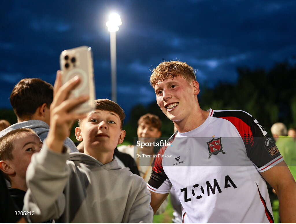 1 August 2025; Rohan Vaughan has his photo taken with a supporter after the SSE Airtricity Men's First Division match between UCD and Dundalk at UCD Bowl in Belfield, Dublin. Photo by Thomas Flinkow/Sportsfile