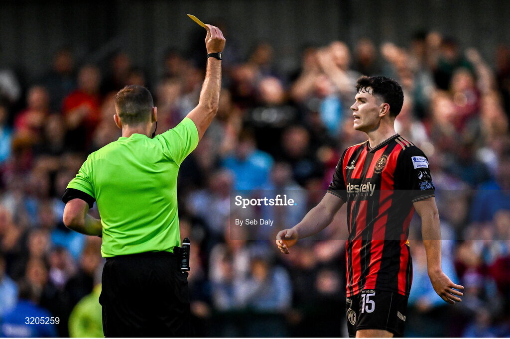 1 August 2025; James Clarke of Bohemians is shown a yellow card by referee Paul Norton during the SSE Airtricity Men's Premier Division match between Bohemians and Drogheda United at Dalymount Park in Dublin. Photo by Seb Daly/Sportsfile