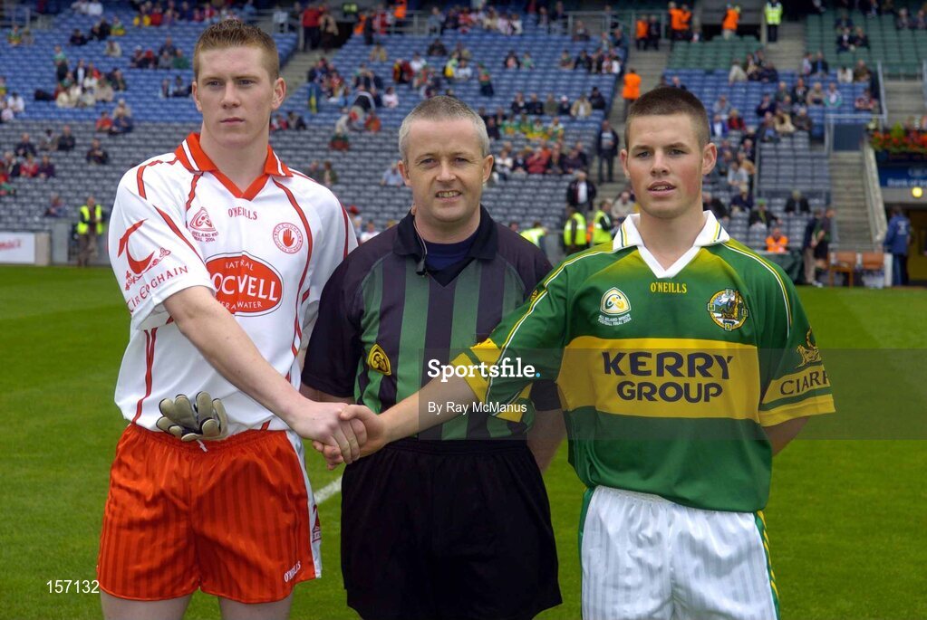 26 September 2004; Tyrone minor captain Marc Cunningham shakes hands with Kerry minor captain Shane Murphy in the presence of referee Tom Quigley. All-Ireland Minor Football Championship Final, Kerry v Tyrone, Croke Park, Dublin. Picture credit; Ray McManus / SPORTSFILE *** Local Caption *** Any photograph taken by SPORTSFILE during, or in connection with, the 2004 All-Ireland Minor Football Final which displays GAA logos or contains an image or part of an image of any GAA intellectual property, or, which contains images of a GAA player/players in their playing uniforms, may only be used for editorial and non-advertising purposes.  Use of photographs for advertising, as posters or for purchase separately is strictly prohibited unless prior written approval has been obtained from the Gaelic Athletic Association.