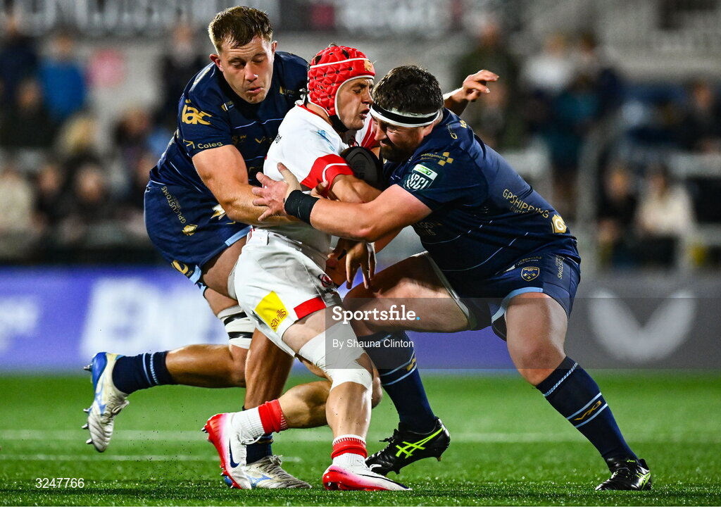 26 September 2025; Michael Lowry of Ulster is tackled by Dragons players Ben Carter, left, and Wyn Jones during the United Rugby Championship match between Ulster and Dragons at Affidea Stadium in Belfast. Photo by Shauna Clinton/Sportsfile