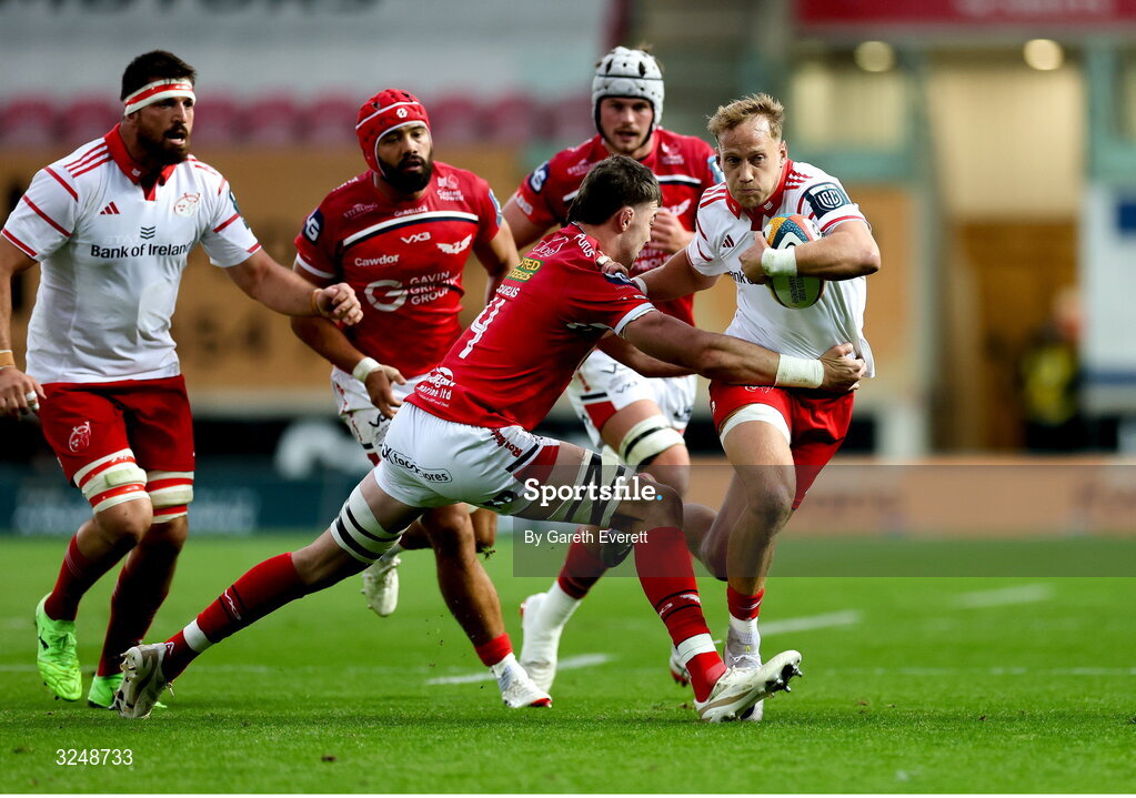 27 September 2025; Mike Haley of Munster is tackled by Sam Lousi of Scarlets during the United Rugby Championship match between Scarlets and Munster at Parc Y Scarlets in Llanelli, Wales. Photo by Gareth Everett/Sportsfile