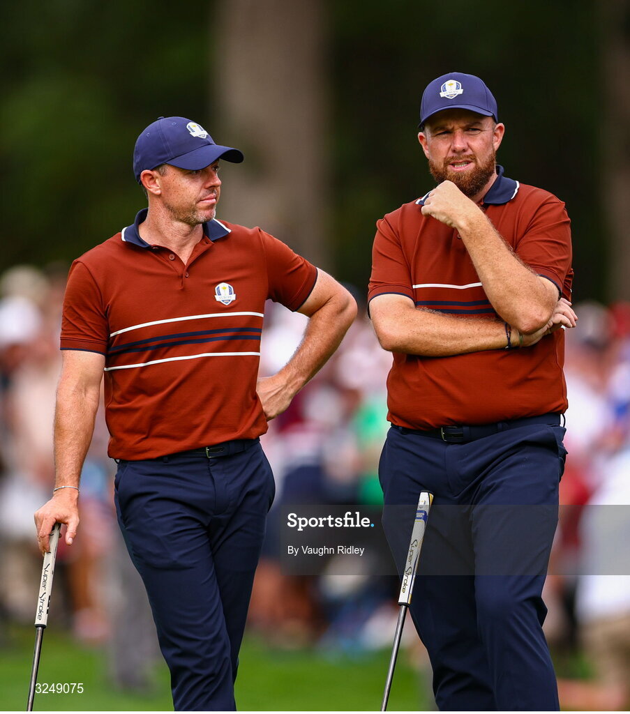 27 September 2025; Rory McIlroy of Europe, left, and Shane Lowry of Europe watch on at the 13th green during the afternoon fourballs on day two of the 2025 Ryder Cup at Black Course at Bethpage State Park Golf Course in Farmingdale, New York, USA. Photo by Vaughn Ridley/Sportsfile