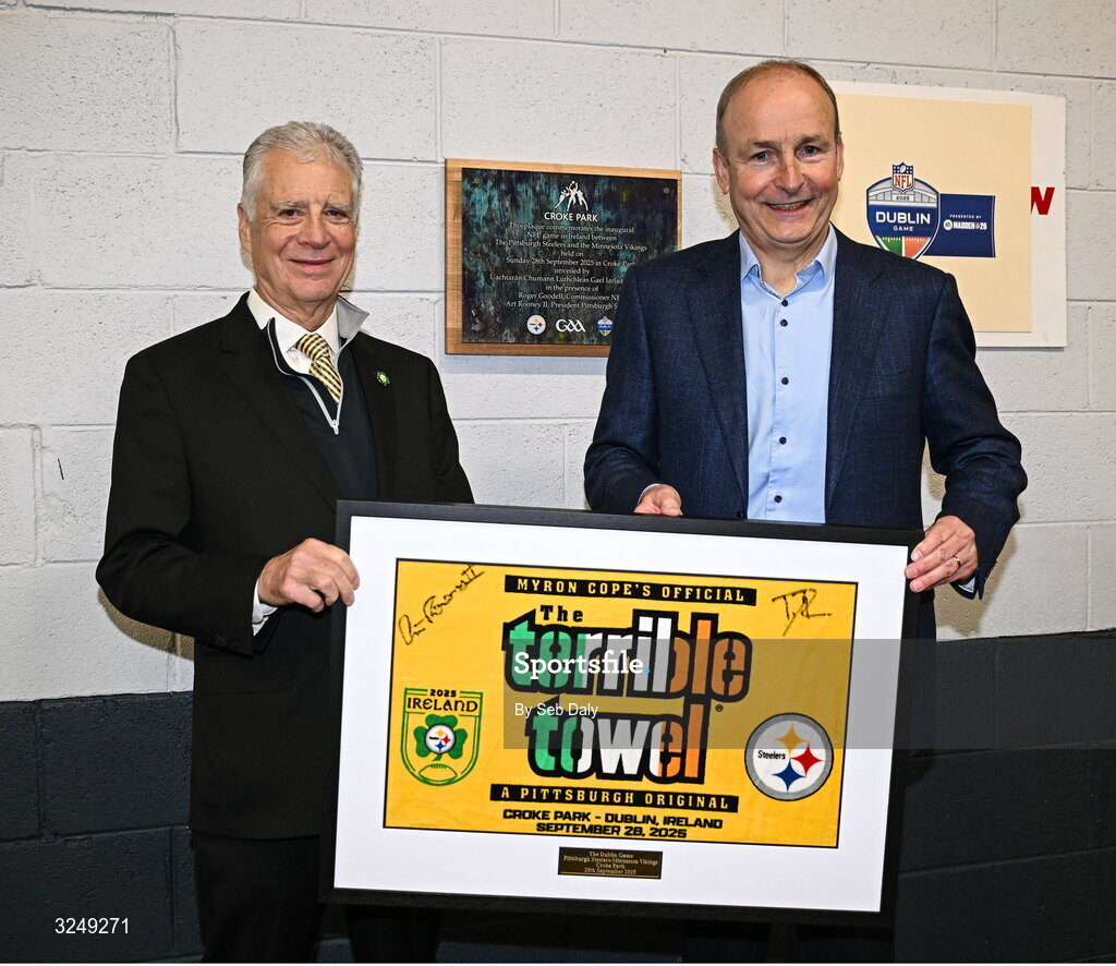 28 September 2025; An Taoiseach Micheál Martin TD is presented with a Terrible Towel by Pittsburgh Steelers vice president Arthur J Rooney Jr before the 2025 NFL International Game between the Pittsburgh Steelers and the Minnesota Vikings at Croke Park in Dublin. Photo by Seb Daly/Sportsfile