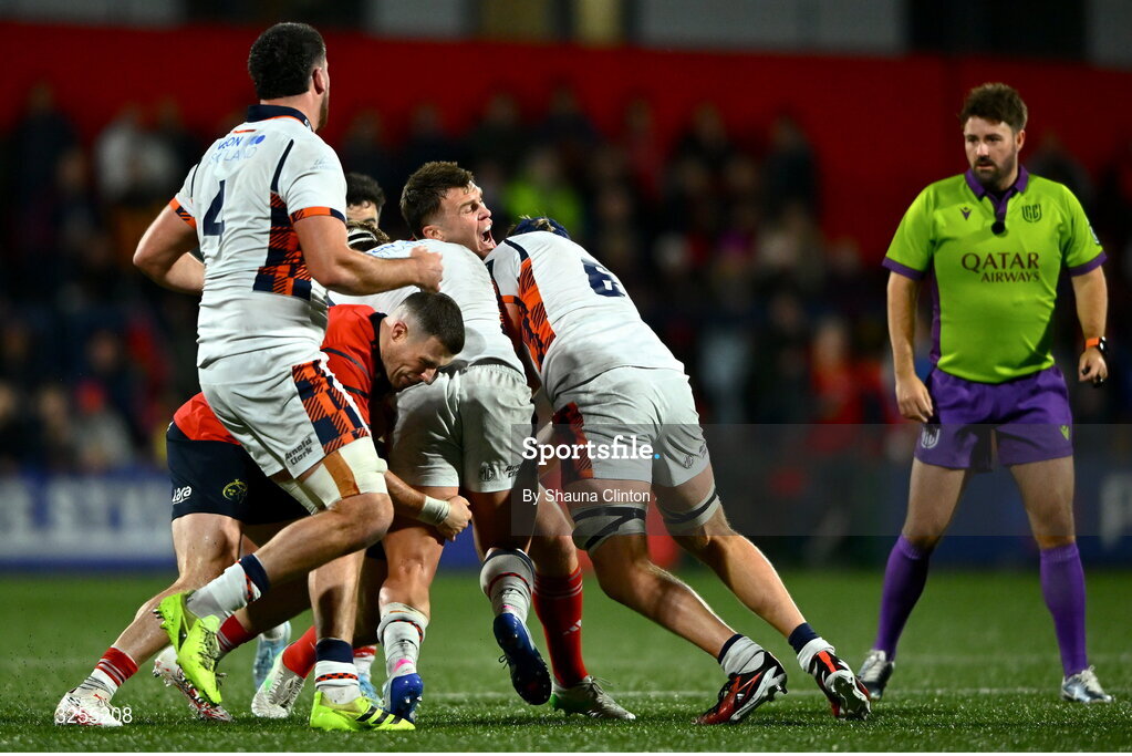 10 October 2025; Tom Farrell of Munster is tackled by Edinburgh players Dylan Richardson, left, and Magnus Bradbury during the United Rugby Championship match between Munster and Edinburgh at Virgin Media Park in Cork. Photo by Shauna Clinton/Sportsfile