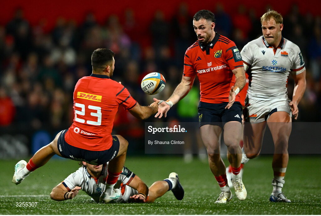 10 October 2025; Dan Kelly of Munster offloads the ball to team-mate Andrew Smith despite the tackle of Wes Goosen of Edinburgh during the United Rugby Championship match between Munster and Edinburgh at Virgin Media Park in Cork. Photo by Shauna Clinton/Sportsfile