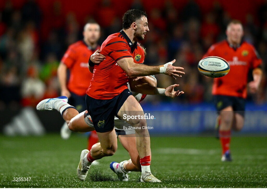 10 October 2025; Andrew Smith of Munster offloads the ball despite the tackle of Dylan Richardson of Edinburgh during the United Rugby Championship match between Munster and Edinburgh at Virgin Media Park in Cork. Photo by Shauna Clinton/Sportsfile