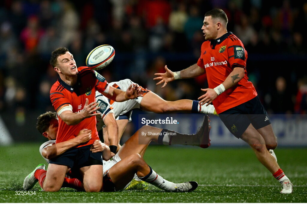 10 October 2025; Tom Farrell of Munster offloads the ball to team-mate Calvin Nash despite the tackle of Piers O'Conor, left, and Darcy Graham of Edinburgh during the United Rugby Championship match between Munster and Edinburgh at Virgin Media Park in Cork. Photo by Shauna Clinton/Sportsfile