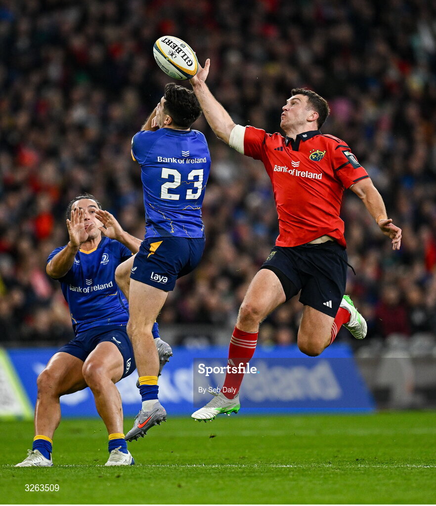 18 October 2025; Tom Farrell of Munster beats Jimmy O'Brien of Leinster to the ball while on his way to scoring his side's second try during the United Rugby Championship match between Leinster and Munster at Croke Park in Dublin. Photo by Seb Daly/Sportsfile