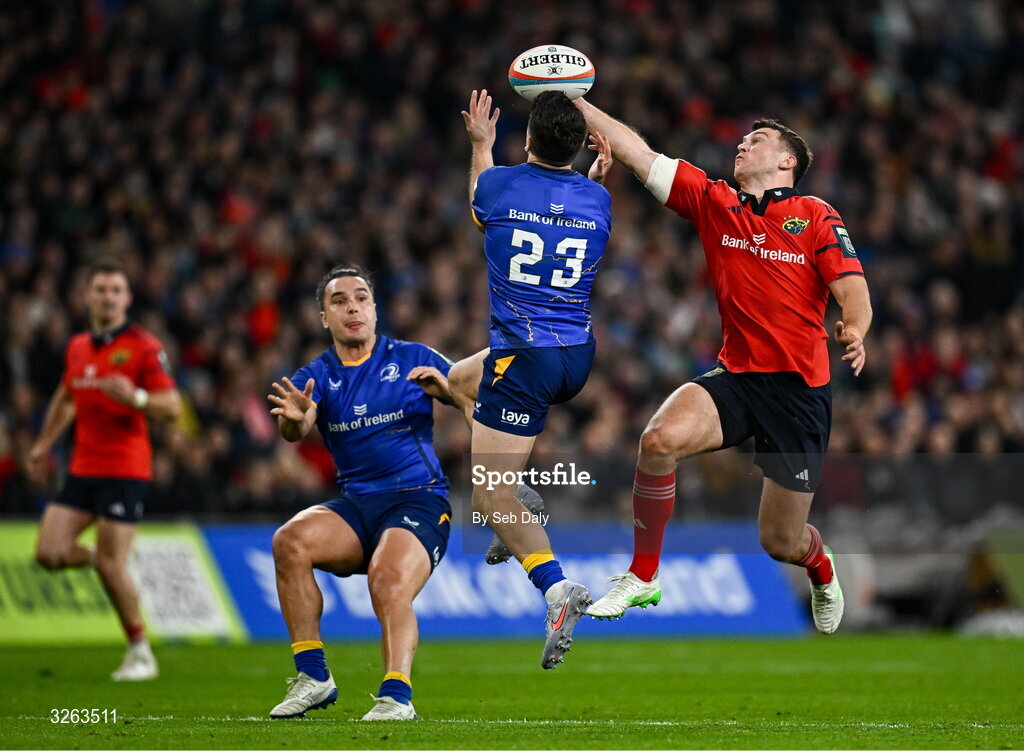 18 October 2025; Tom Farrell of Munster beats Jimmy O'Brien of Leinster to the ball while on his way to scoring his side's second try during the United Rugby Championship match between Leinster and Munster at Croke Park in Dublin. Photo by Seb Daly/Sportsfile