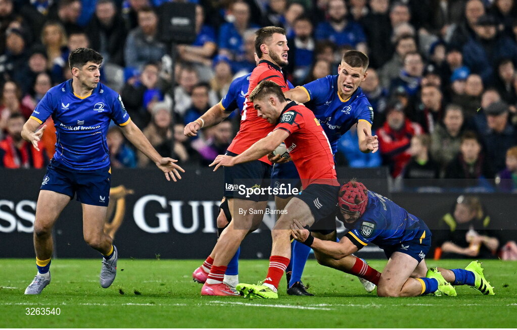 18 October 2025; Jack Crowley of Munster is tackled by Josh van der Flier, bottom, and Sam Prendergast during the United Rugby Championship match between Leinster and Munster at Croke Park in Dublin. Photo by Sam Barnes/Sportsfile