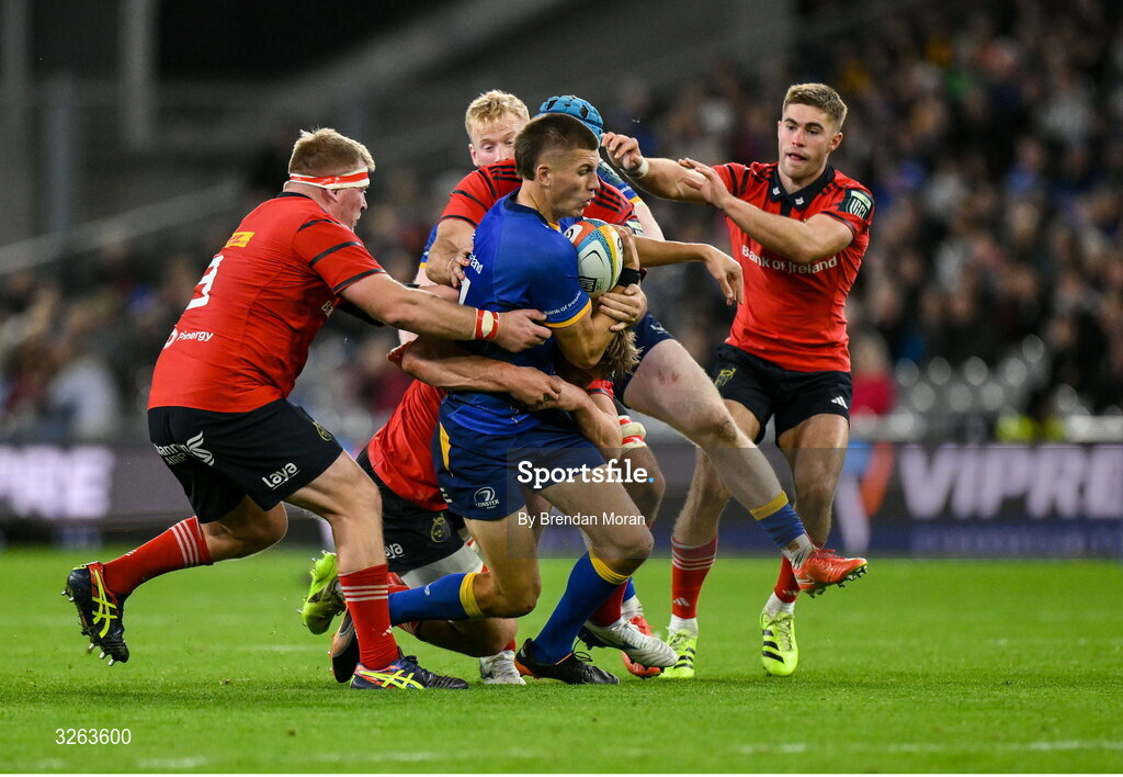 18 October 2025; Sam Prendergast of Leinster is tackled by Munster players, from left, John Ryan, Gavin Coombes and Jack Crowley during the United Rugby Championship match between Leinster and Munster at Croke Park in Dublin. Photo by Brendan Moran/Sportsfile
