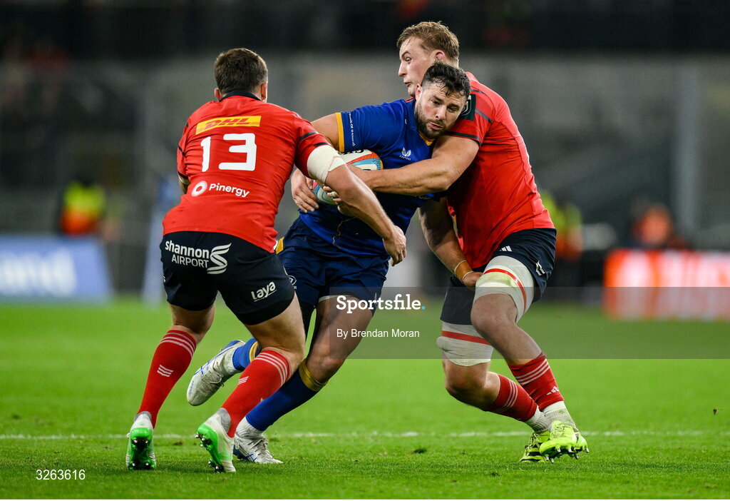 18 October 2025; Robbie Henshaw of Leinster is tackled by Tom Farrell, left, and Dan Kelly of Munster during the United Rugby Championship match between Leinster and Munster at Croke Park in Dublin. Photo by Brendan Moran/Sportsfile