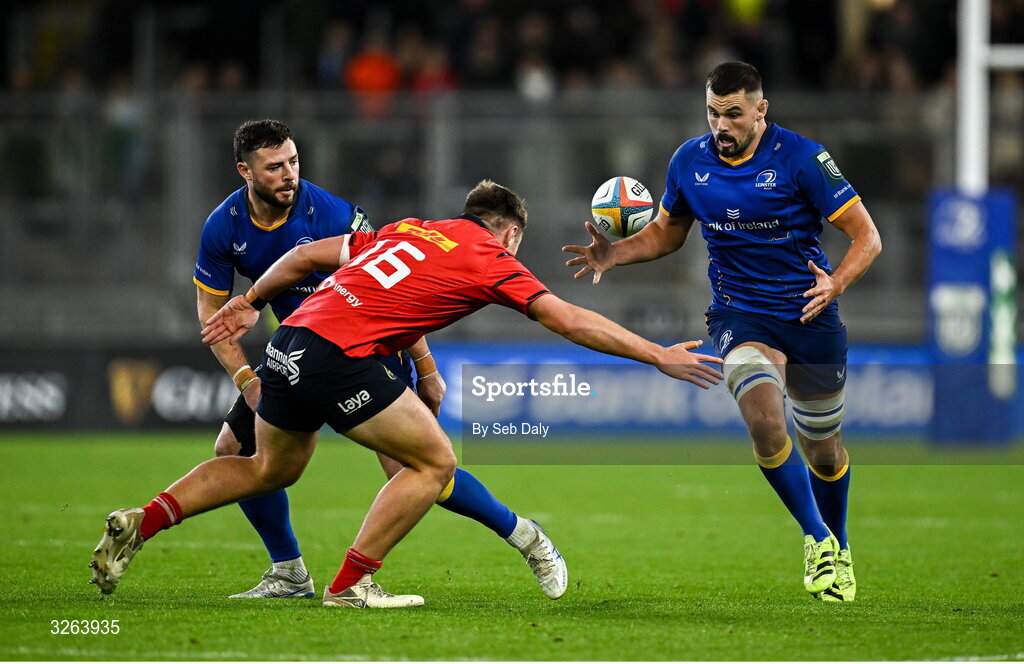 18 October 2025; Leinster players Max Deegan, right, and Robbie Henshaw in action against Lee Barron of Munster during the United Rugby Championship match between Leinster and Munster at Croke Park in Dublin. Photo by Seb Daly/Sportsfile