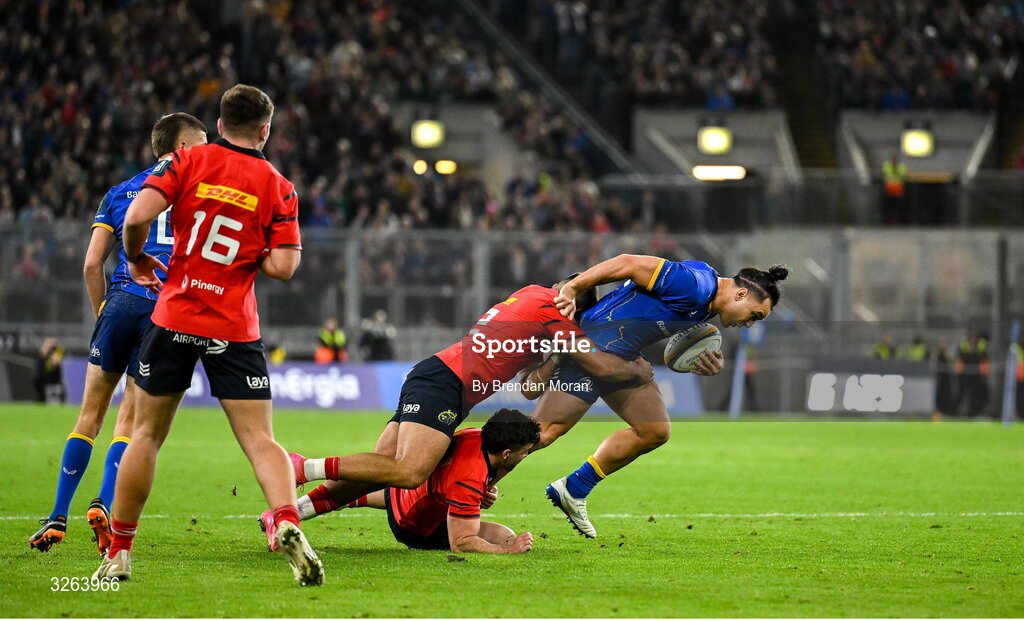 18 October 2025; James Lowe of Leinster is tackled by Paddy Patterson and Dan Kelly of Munster during the United Rugby Championship match between Leinster and Munster at Croke Park in Dublin. Photo by Brendan Moran/Sportsfile