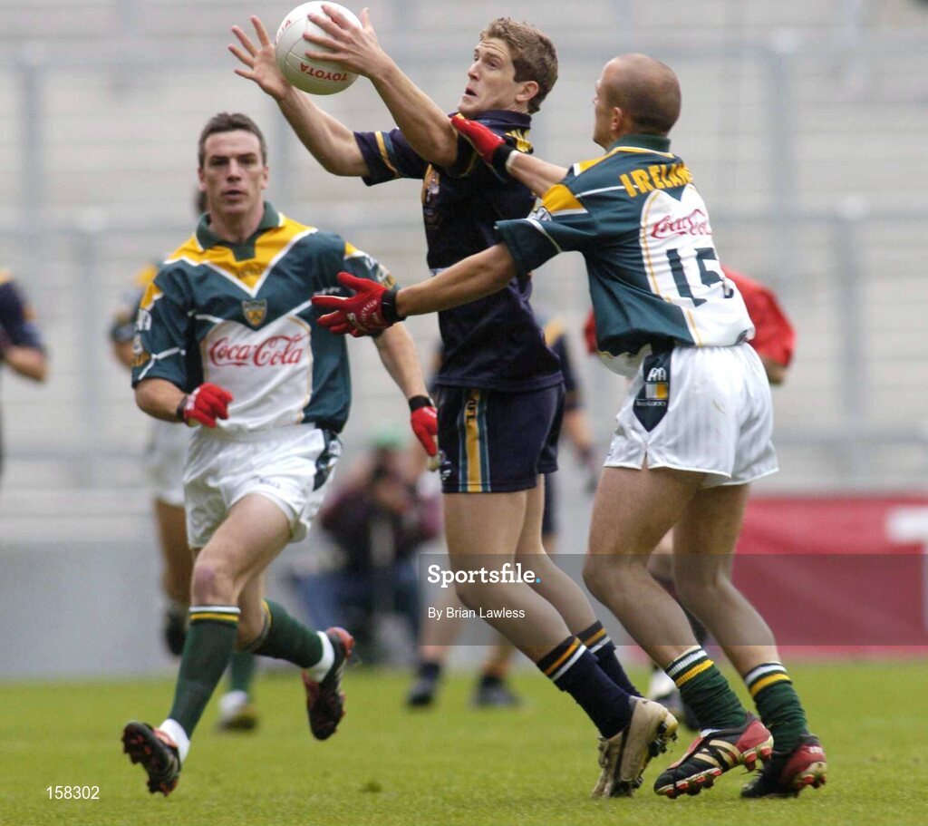 17 October 2004; Nick Dal Santo, Australia, in action against Tom Kelly and Padraic Joyce, left, Ireland. Coca Cola International Rules Series 2004, First Test, Ireland v Australia, Croke Park, Dublin. Picture credit; Brian Lawless / SPORTSFILE *** Local Caption *** Any photograph taken by SPORTSFILE during, or in connection with, the 2004 Coca Cola International Rules Series which displays GAA logos or contains an image or part of an image of any GAA intellectual property, or, which contains images of a GAA player/players in their playing uniforms, may only be used for editorial and non-advertising purposes.  Use of photographs for advertising, as posters or for purchase separately is strictly prohibited unless prior written approval has been obtained from the Gaelic Athletic Association.