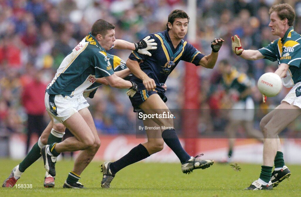17 October 2004; Andrew Embley, Australia, in action against Sean Cavanagh, left, and James Nallen, Ireland. Coca Cola International Rules Series 2004, First Test, Ireland v Australia, Croke Park, Dublin. Picture credit; Brendan Moran / SPORTSFILE *** Local Caption *** Any photograph taken by SPORTSFILE during, or in connection with, the 2004 Coca Cola International Rules Series which displays GAA logos or contains an image or part of an image of any GAA intellectual property, or, which contains images of a GAA player/players in their playing uniforms, may only be used for editorial and non-advertising purposes.  Use of photographs for advertising, as posters or for purchase separately is strictly prohibited unless prior written approval has been obtained from the Gaelic Athletic Association.