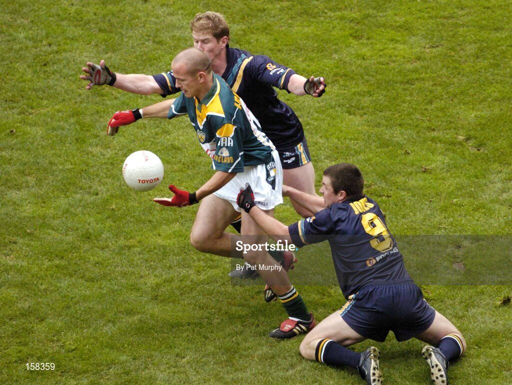 17 October 2004; Tom Kelly, Ireland, in action against Austinn Jones, 9, and Adam McPhee, Australia. Coca Cola International Rules Series 2004, First Test, Ireland v Australia, Croke Park, Dublin. Picture credit; Pat Murphy / SPORTSFILE *** Local Caption *** Any photograph taken by SPORTSFILE during, or in connection with, the 2004 Coca Cola International Rules Series which displays GAA logos or contains an image or part of an image of any GAA intellectual property, or, which contains images of a GAA player/players in their playing uniforms, may only be used for editorial and non-advertising purposes.  Use of photographs for advertising, as posters or for purchase separately is strictly prohibited unless prior written approval has been obtained from the Gaelic Athletic Association.