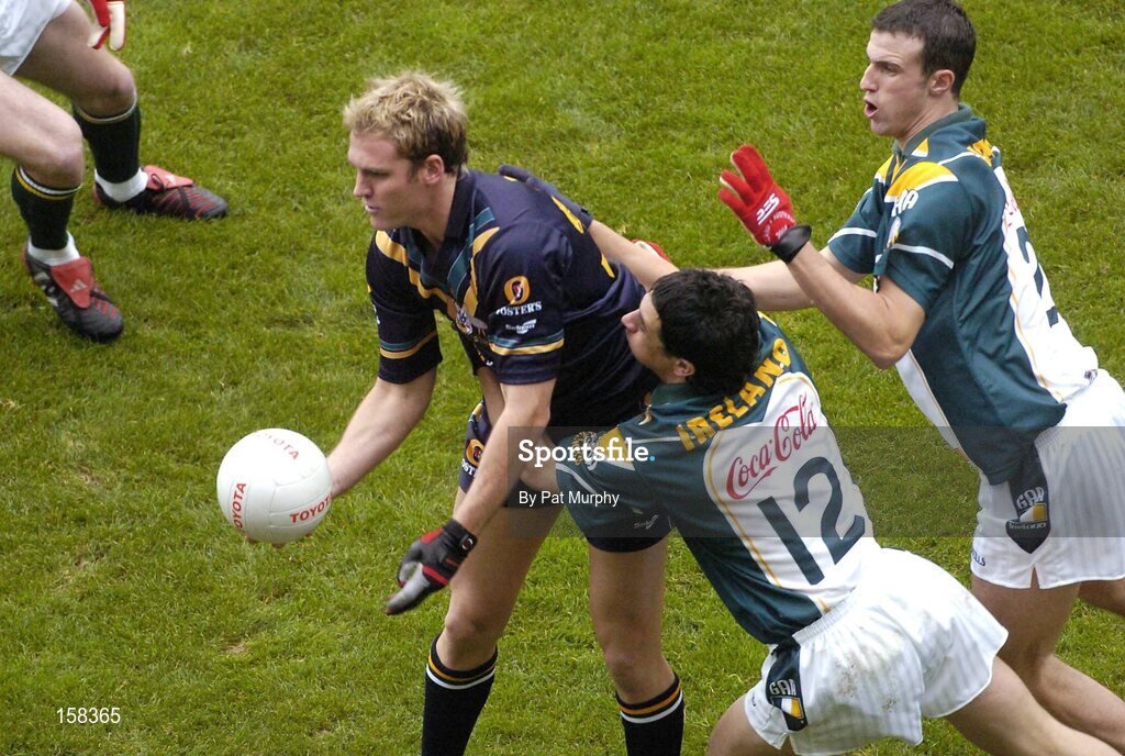 17 October 2004; Cameron Bruce, Australia, in action against Paul Galvin, 12, and Joe Bergin, Ireland. Coca Cola International Rules Series 2004, First Test, Ireland v Australia, Croke Park, Dublin. Picture credit; Pat Murphy / SPORTSFILE *** Local Caption *** Any photograph taken by SPORTSFILE during, or in connection with, the 2004 Coca Cola International Rules Series which displays GAA logos or contains an image or part of an image of any GAA intellectual property, or, which contains images of a GAA player/players in their playing uniforms, may only be used for editorial and non-advertising purposes.  Use of photographs for advertising, as posters or for purchase separately is strictly prohibited unless prior written approval has been obtained from the Gaelic Athletic Association.