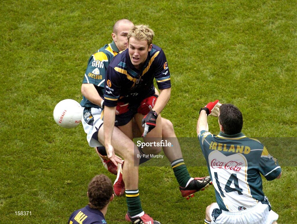 17 October 2004; Cameron Bruce, Australia, in action against Tom Kelly, and Padraic Joyce, 14, Ireland. Coca Cola International Rules Series 2004, First Test, Ireland v Australia, Croke Park, Dublin. Picture credit; Pat Murphy / SPORTSFILE *** Local Caption *** Any photograph taken by SPORTSFILE during, or in connection with, the 2004 Coca Cola International Rules Series which displays GAA logos or contains an image or part of an image of any GAA intellectual property, or, which contains images of a GAA player/players in their playing uniforms, may only be used for editorial and non-advertising purposes.  Use of photographs for advertising, as posters or for purchase separately is strictly prohibited unless prior written approval has been obtained from the Gaelic Athletic Association.