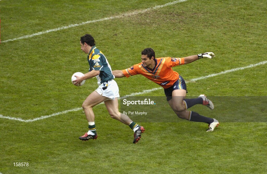 17 October 2004; Paul Galvin, Ireland, goes past the challenge of Australia's Mal Michael on his way to scoring an over. Coca Cola International Rules Series 2004, First Test, Ireland v Australia, Croke Park, Dublin. Picture credit; Pat Murphy / SPORTSFILE *** Local Caption *** Any photograph taken by SPORTSFILE during, or in connection with, the 2004 Coca Cola International Rules Series, which displays GAA logos or contains an image or part of an image of any GAA intellectual property, or, which contains images of a GAA player/players in their playing uniforms, may only be used for editorial and non-advertising purposes.  Use of photographs for advertising, as posters or for purchase separately is strictly prohibited unless prior written approval has been obtained from the Gaelic Athletic Association.