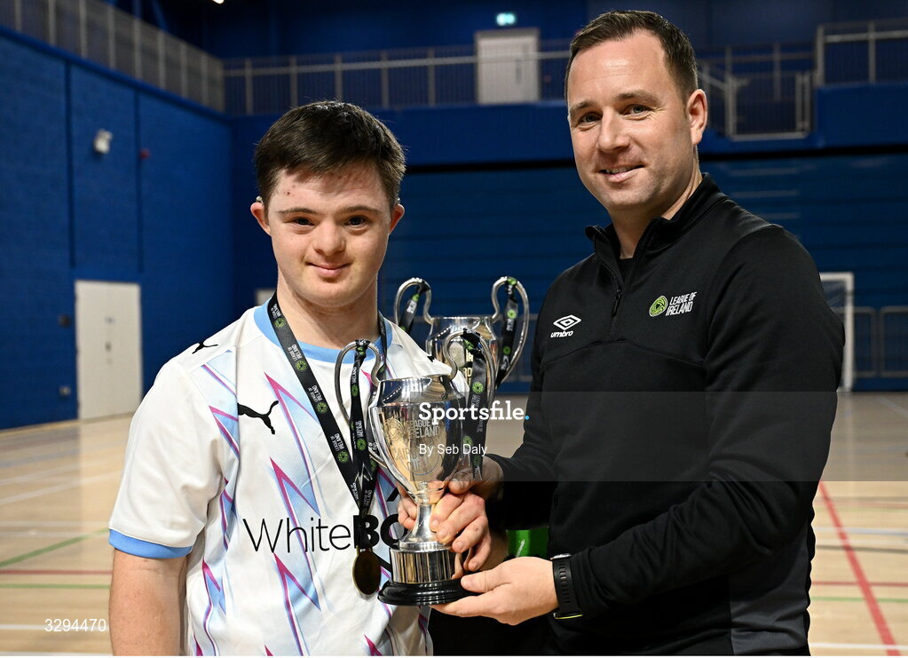 16 November 2025; Waterford captain Sean Toolin is presented with the championship cup by League of Ireland director Mark Scanlon at LOI Cairdeas Cup Festival at the National Indoor Arena on the Sport Ireland Campus in Dublin. Photo by Seb Daly/Sportsfile