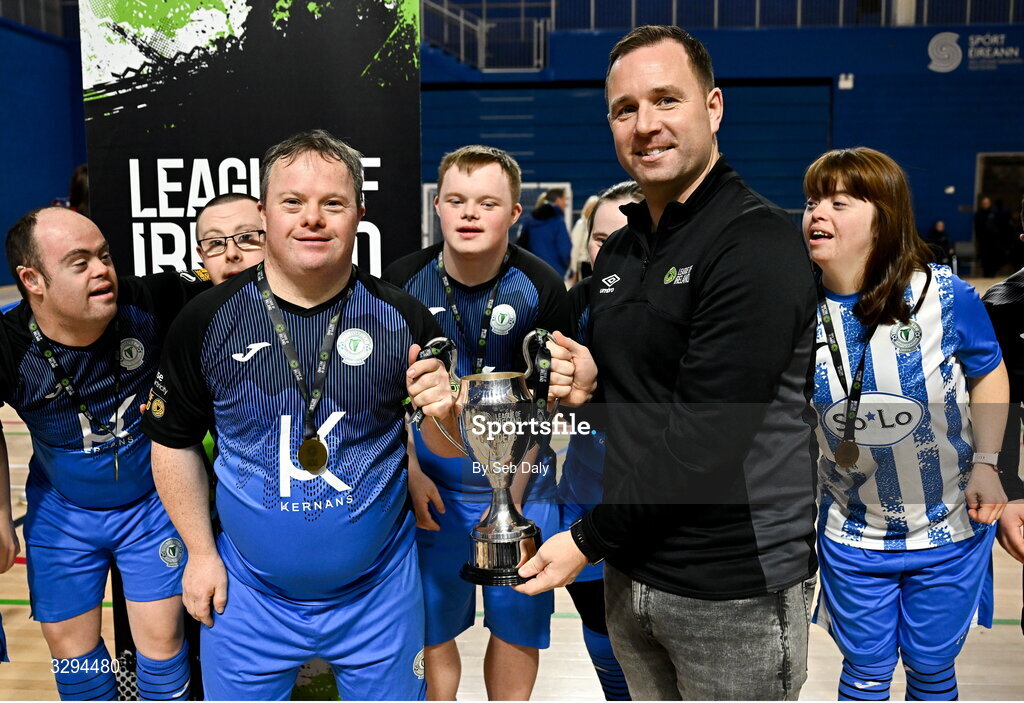 16 November 2025; Finn Harps captain Hughie Sweeney is presented with the premiership cup by League of Ireland director Mark Scanlon at the LOI Cairdeas Cup Festival match between TEAM and TEAM at the National Indoor Arena on the Sport Ireland Campus in Dublin. Photo by Seb Daly/Sportsfile