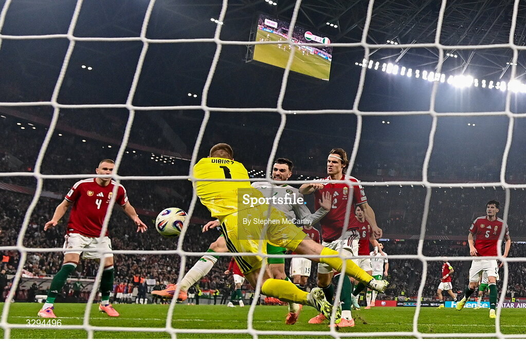 16 November 2025; Troy Parrott of Republic of Ireland scores his side's third goal past Hungary goalkeeper Dénes Dibusz during the FIFA World Cup 2026 Group F Qualifier match between Hungary and Republic of Ireland at Puskás Aréna in Budapest, Hungary. Photo by Stephen McCarthy/Sportsfile