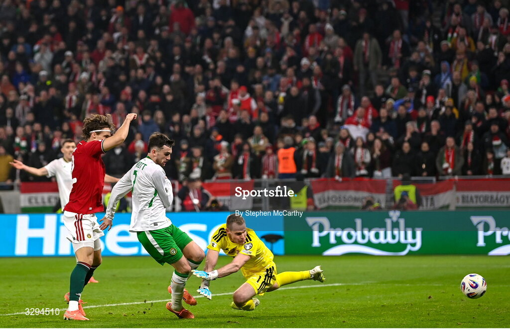16 November 2025; Troy Parrott of Republic of Ireland scores his side's third goal past Hungary goalkeeper Dénes Dibusz during the FIFA World Cup 2026 Group F Qualifier match between Hungary and Republic of Ireland at Puskás Aréna in Budapest, Hungary. Photo by Stephen McCarthy/Sportsfile