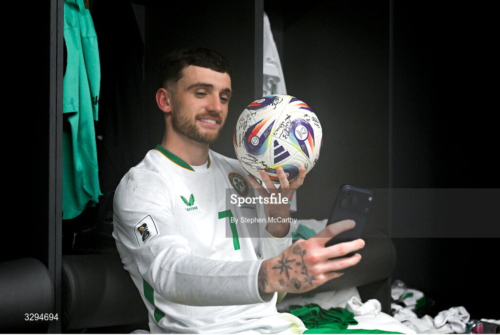 16 November 2025; Troy Parrott of Republic of Ireland celebrates with the match ball in the dressing room after scoring a hat-trick in the FIFA World Cup 2026 Group F Qualifier match between Hungary and Republic of Ireland at Puskás Aréna in Budapest, Hungary. Photo by Stephen McCarthy/Sportsfile