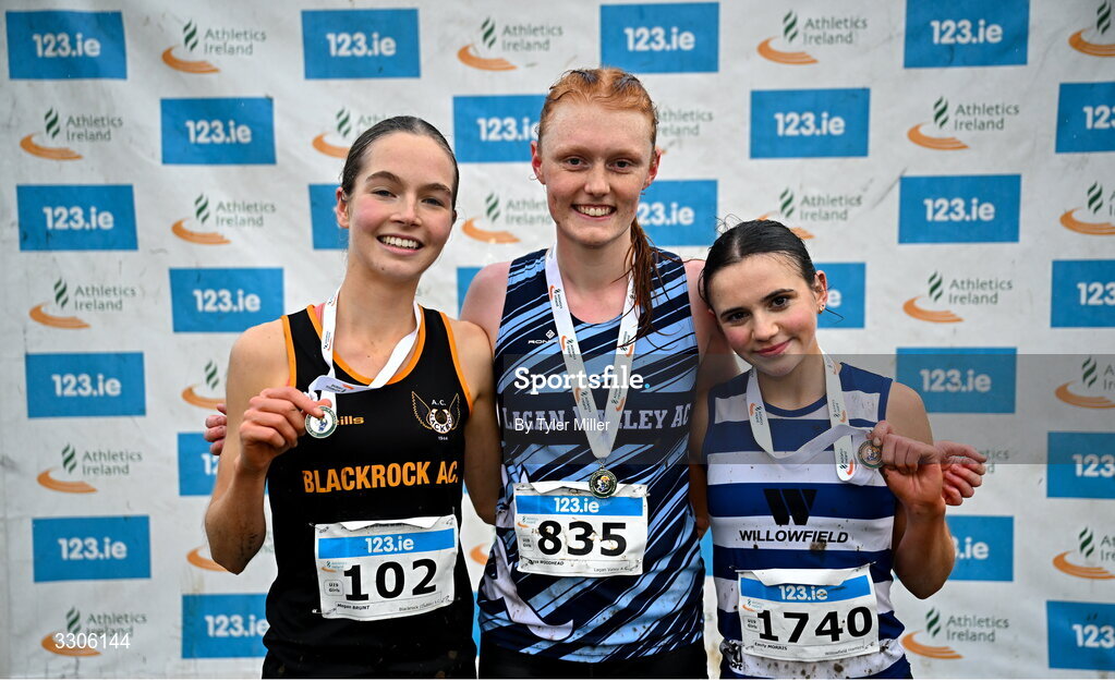 7 December 2025; U19 Girls 5000m medalists, from left, Megan Brunt of Blackrock AC, Dublin, silver, Freya Woodhead of Lagan Valley AC, Antrim, gold, and Emily Morris of Willowfield Harriers, Antrim, after competing in the U19 Girls 5000m during the 123.ie National Novice and Juvenile Uneven Age Cross Country Championships at the Sport Ireland National Cross Country Track in Abbotstown, Dublin. Photo by Tyler Miller/Sportsfile