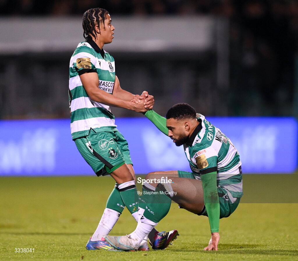 31 January 2026; Jake Mulraney is helped up by Shamrock Rovers team-mate Victor Ozhianvuna during the 2026 Men's President's Cup final match between Shamrock Rovers and Derry City at Tallaght Stadium in Dublin. Photo by Stephen McCarthy/Sportsfile