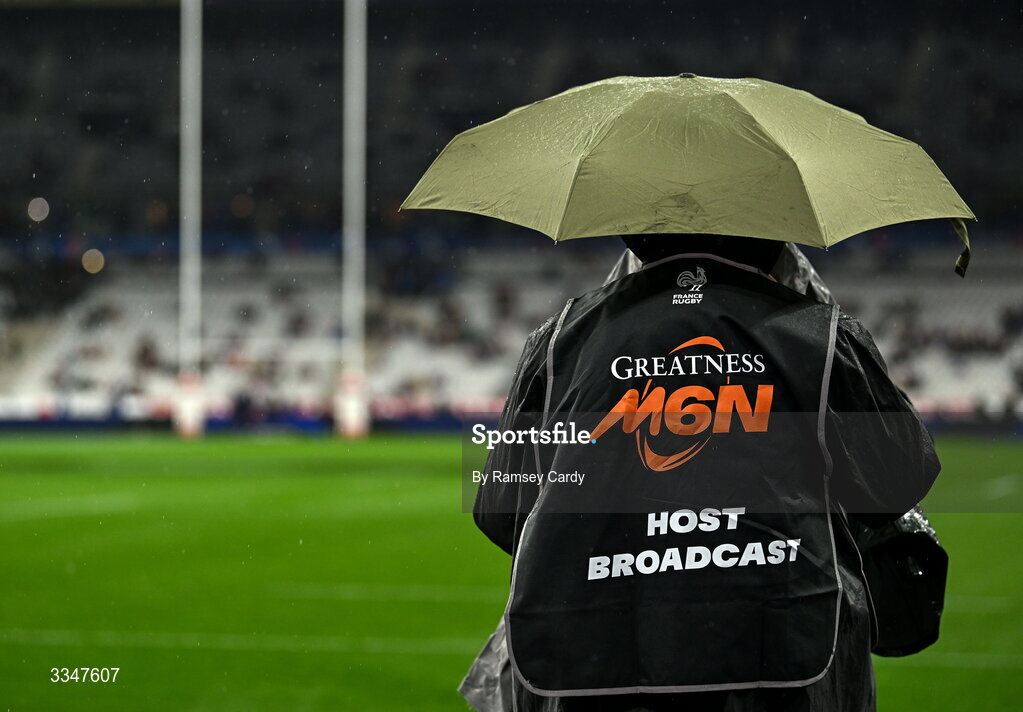 5 February 2026; A camera operator takes shelter from the rain before the Guinness 6 Nations Rugby Championship match between France and Ireland at Stade de France in Paris, France. Photo by Ramsey Cardy/Sportsfile