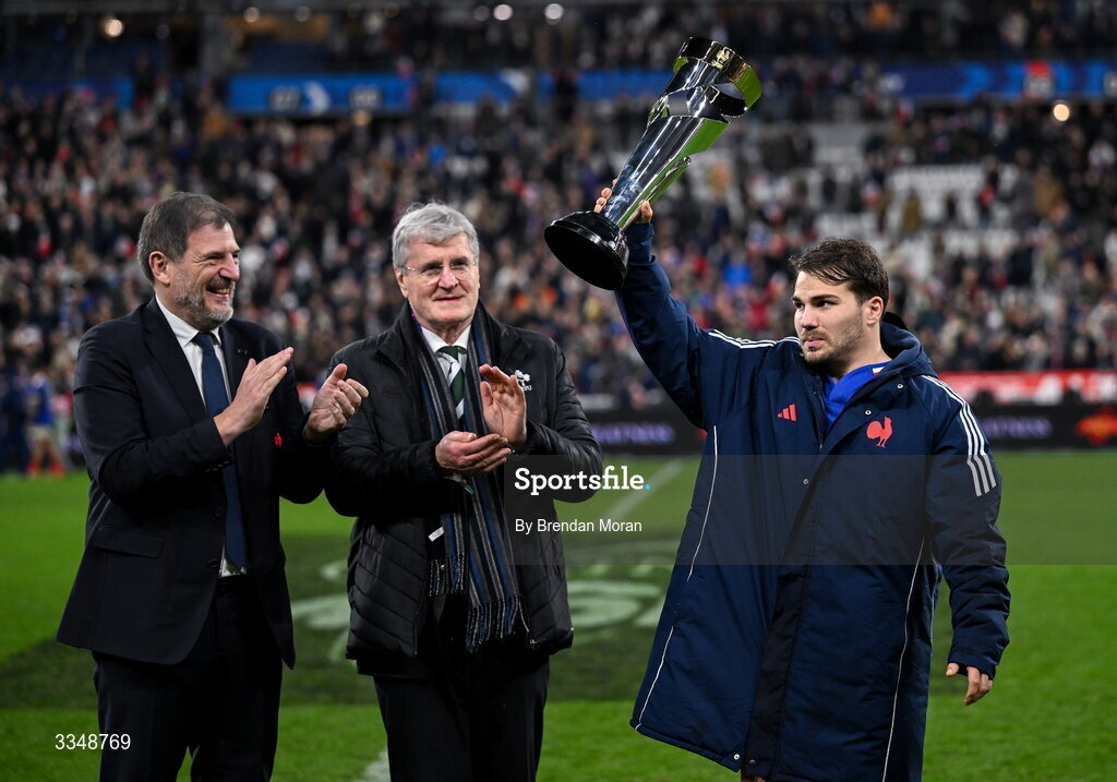 5 February 2026; France captain Antoine Dupont lifts the Solidarity Cup, in the company of FFR president Florian Grill, left, and IRFU president John O'Driscoll after the Guinness 6 Nations Rugby Championship match between France and Ireland at Stade de France in Paris, France. Photo by Brendan Moran/Sportsfile