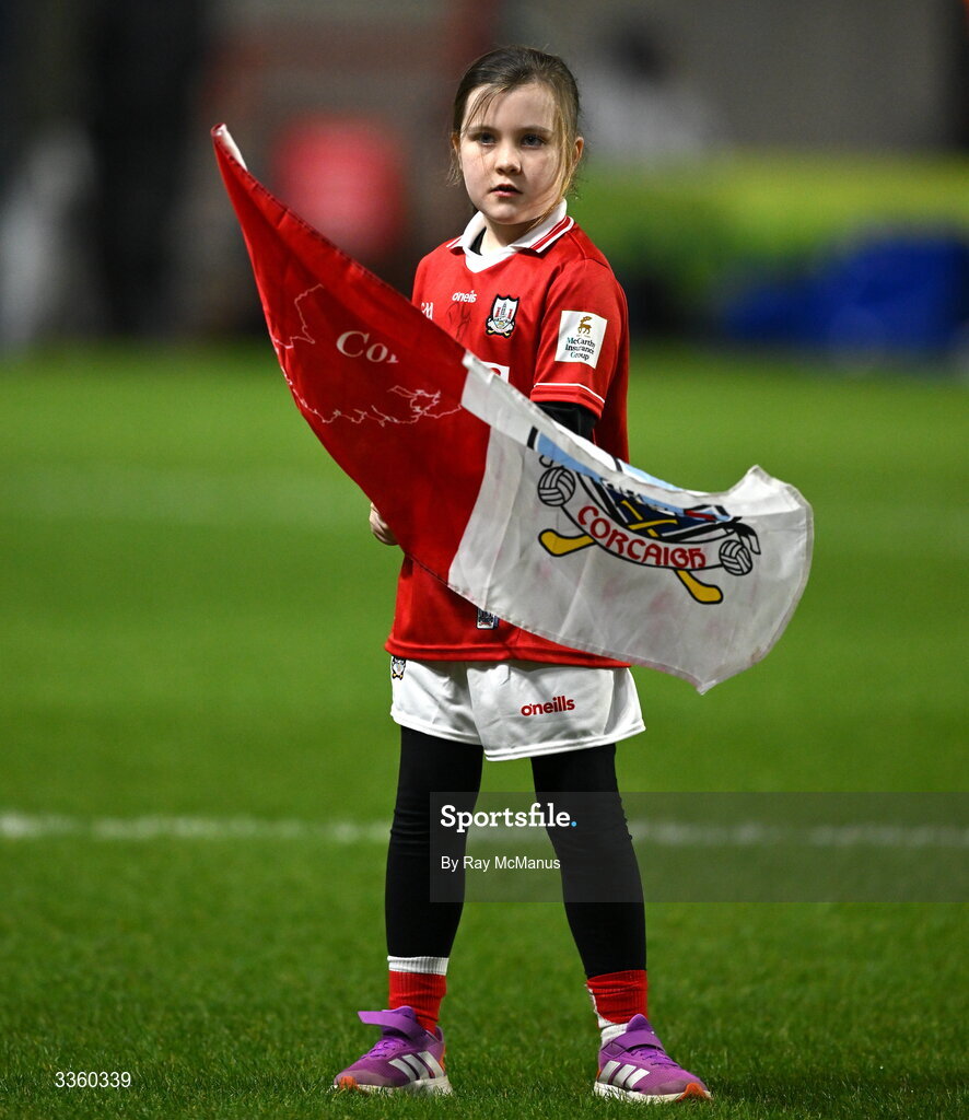 7 February 2026; Cork mascot Anna O'Flynn waves a flag before the Allianz Hurling League Division 1A match between Cork and Tipperary at SuperValu Páirc Ui Chaoimh in Cork. Photo by Ray McManus/Sportsfile