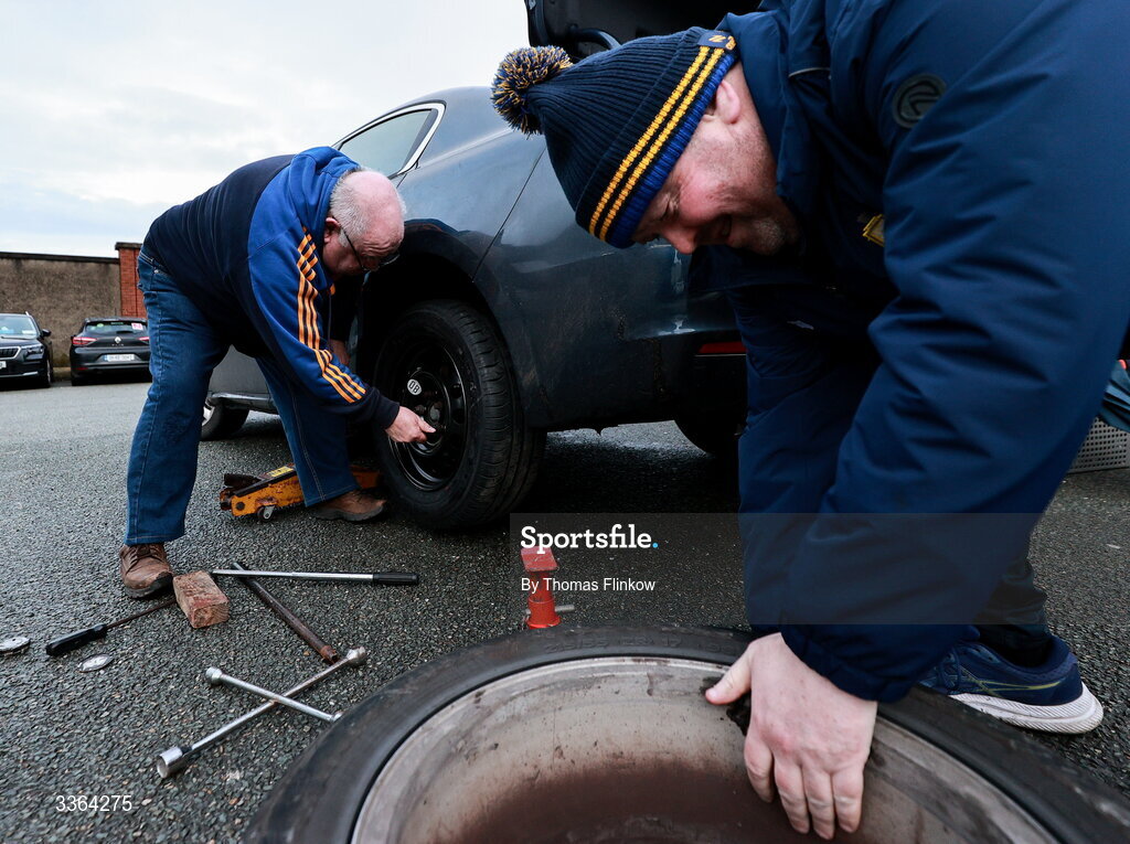 21 February 2026; Clare supporters Tom Sheehan, back, and Tom Keogh, both from Sixmilebridge in Clare, change a flat tyre outside the grounds before the Allianz Hurling League Division 1B match between Kildare and Clare at Cedral St Conleth's Park in Newbridge, Kildare. Photo by Thomas Flinkow/Sportsfile