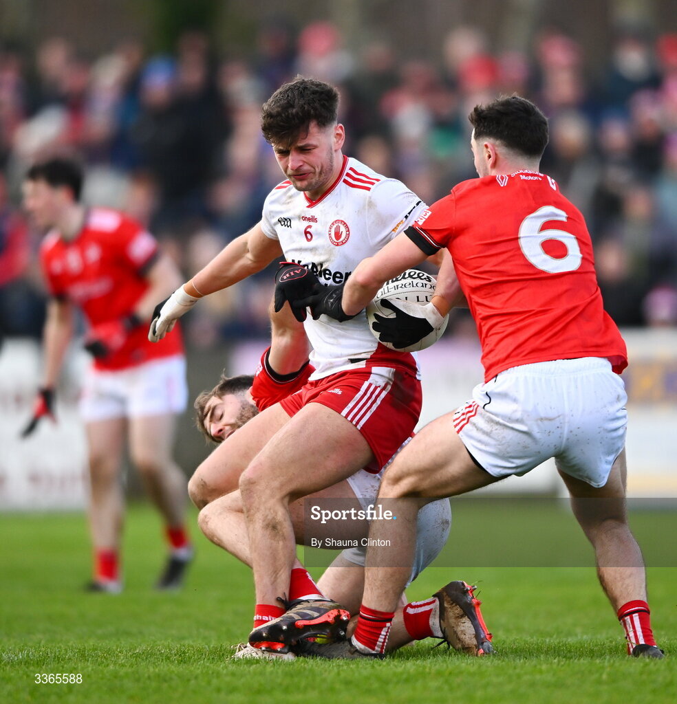 22 February 2026; Michael McKernan of Tyrone is fouled by Louth players Dermot Campbell, left, and Emmett Carolan during the Allianz Football League Division 2 match between Louth and Tyrone at DEFY Pairc Mhuire in Ardee, Louth. Photo by Shauna Clinton/Sportsfile