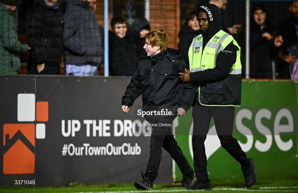 27 February 2026; A pitch invader is escorted by security off the pitch during the SSE Airtricity Men's Premier Division match between Drogheda United and Shelbourne at Sullivan & Lambe Park in Drogheda, Louth. Photo by Shauna Clinton/Sportsfile