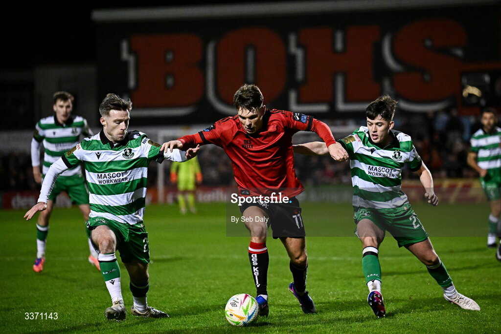 27 February 2026; Dayle Rooney of Bohemians in action against Shamrock Rovers players Jack Byrne, left, and Cory O'Sullivan during the SSE Airtricity Men's Premier Division match between Bohemians and Shamrock Rovers at Dalymount Park in Dublin. Photo by Seb Daly/Sportsfile