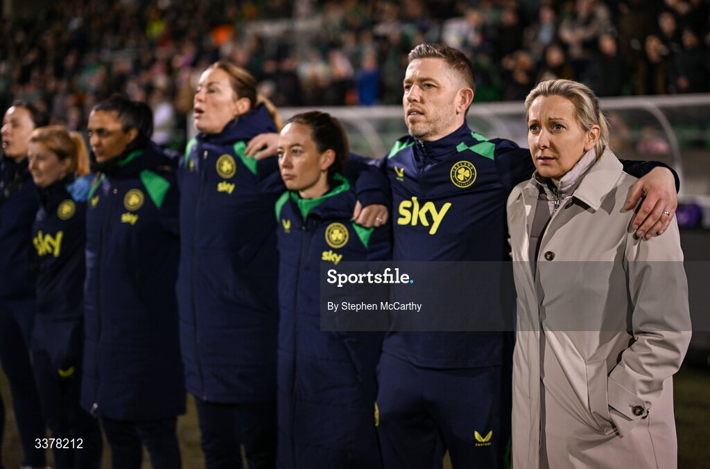 3 March 2026; Republic of Ireland head coach Carla Ward and coaches, from right, assistant coach Gary Cronin, assistant coach Amber Whiteley, goalkeeping coach Emma Byrne, performance analyst Jasmine Mander and performance coach Holly Pickett stand for Amhrán na bhFiann before the 2027 FIFA Women’s World Cup Qualifier match between Republic of Ireland and France at Tallaght Stadium in Dublin. Photo by Stephen McCarthy/Sportsfile
