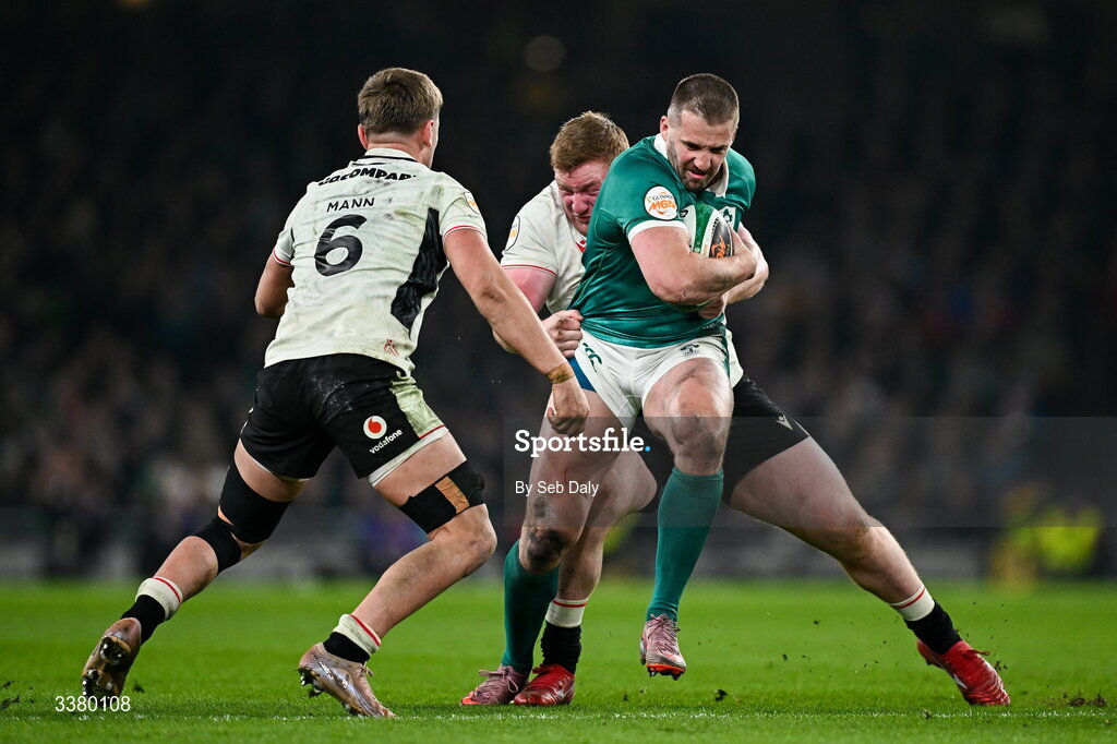 6 March 2026; Stuart McCloskey of Ireland is tackled by Wales players Alex Mann, left, and James Botham during the Guinness 6 Nations Rugby Championship match between Ireland and Wales at the Aviva Stadium in Dublin. Photo by Seb Daly/Sportsfile