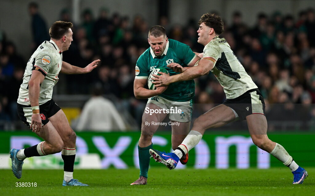 6 March 2026; Stuart McCloskey of Ireland is tackled by Wales players Josh Adams, left, and Eddie James during the Guinness 6 Nations Rugby Championship match between Ireland and Wales at the Aviva Stadium in Dublin. Photo by Ramsey Cardy/Sportsfile