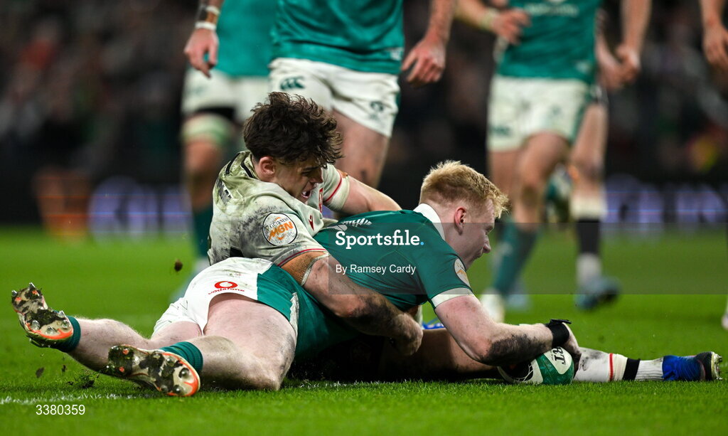 6 March 2026; Jamie Osborne of Ireland scores his side's fourth try despite the efforts from Eddie James of Wales during the Guinness 6 Nations Rugby Championship match between Ireland and Wales at the Aviva Stadium in Dublin. Photo by Ramsey Cardy/Sportsfile