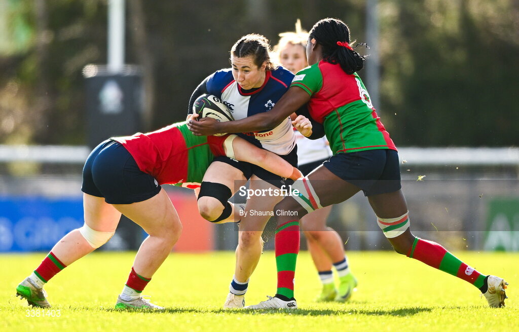 7 March 2026; Eve Higgins of Wolfhounds is tackled by Clovers players Siobhán McCarthy, left, and Faith Oviawe during the Celtic Challenge Round 10 match between Wolfhounds and Clovers at Belfield Bowl in Dublin. Photo by Shauna Clinton/Sportsfile