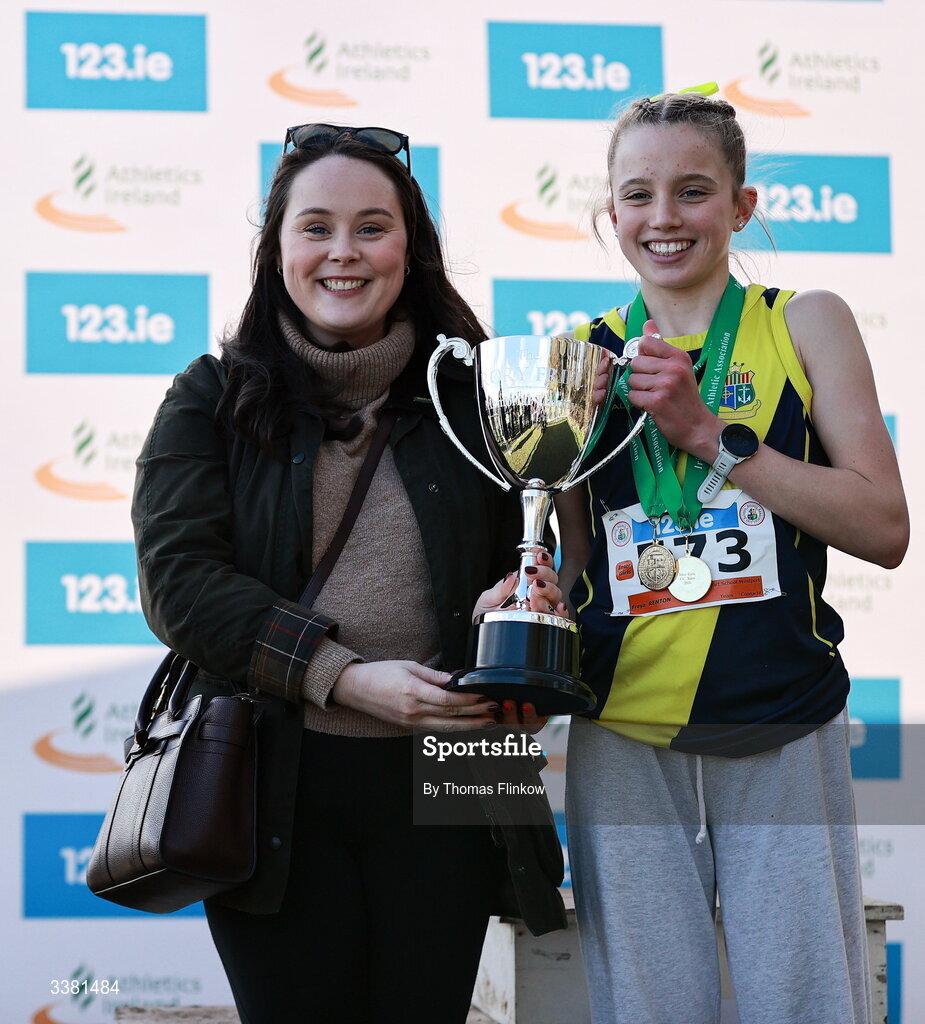 7 March 2026; Nicola Friel, daughter of the late Rory Friel, presents Freya Renton of Sacred Heart School Westport, Mayo, with the Rory Friel Memorial Trophy after the 123.ie All Ireland Schools’ Cross Country Championships at Mallusk Playing Fields in Newtownabbey, Antrim. Photo by Thomas Flinkow/Sportsfile