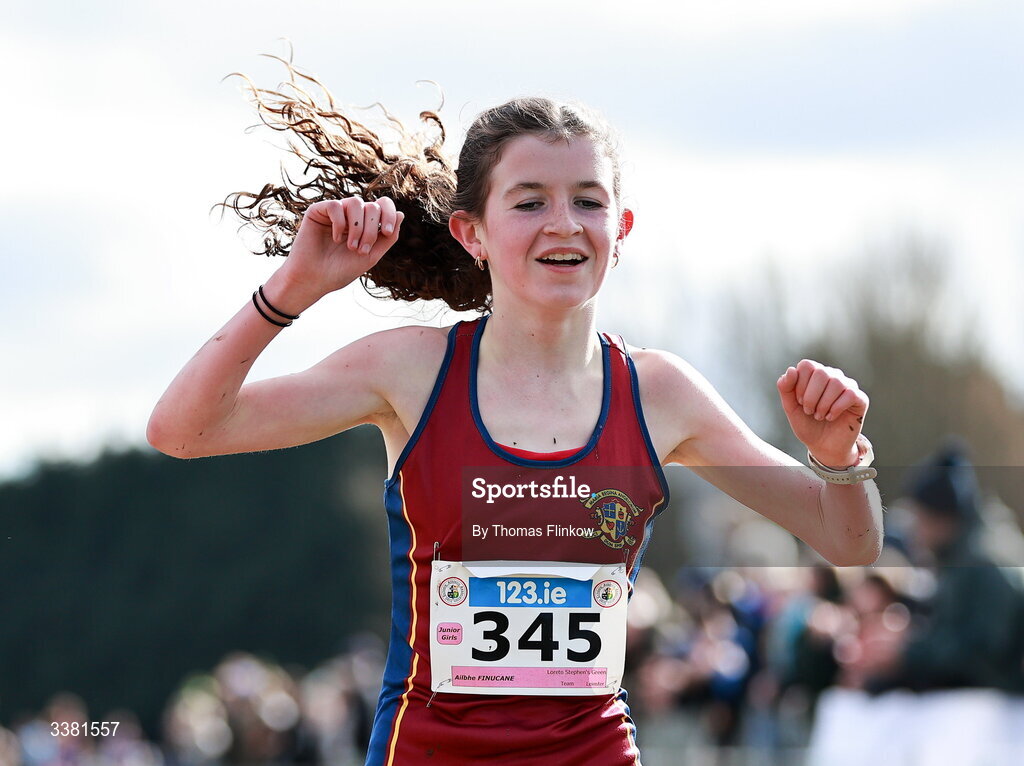 7 March 2026; Ailbhe Finucane of Loreto Stephen's Green, Dublin, celebrates at the finish line after winning the junior girls event during the 123.ie All Ireland Schools’ Cross Country Championships at Mallusk Playing Fields in Newtownabbey, Antrim. Photo by Thomas Flinkow/Sportsfile