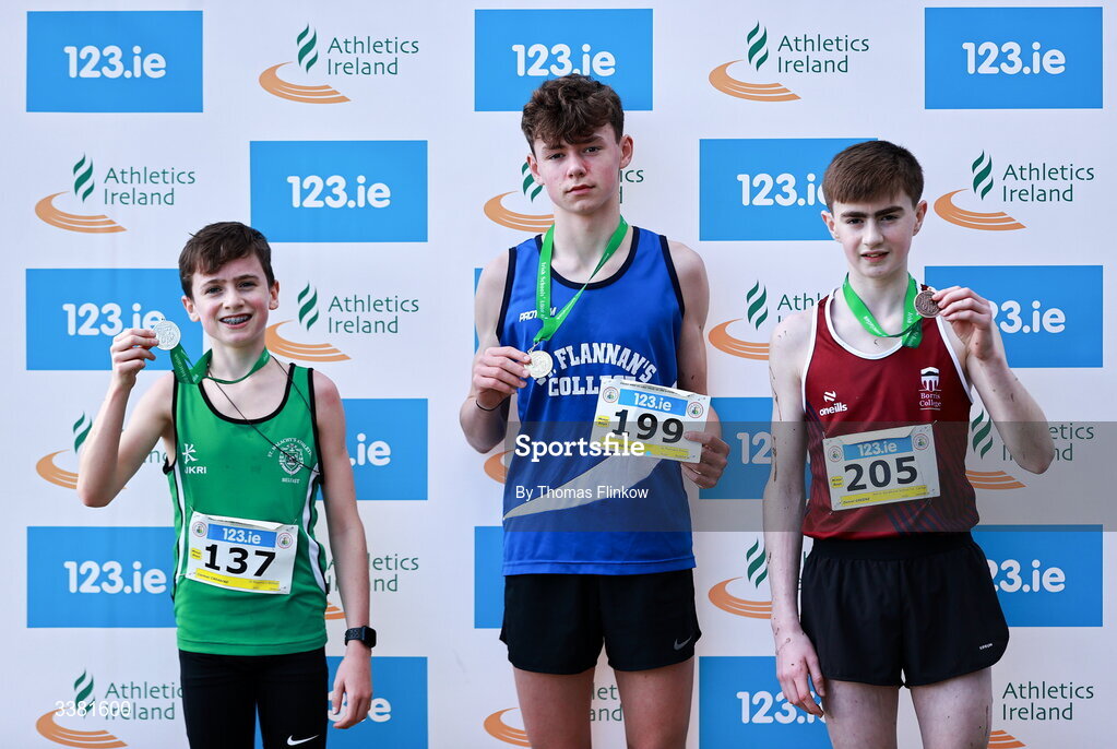 7 March 2026; Stephen Geraghty of St Flannans Ennis, Clare, centre, Cormac Carabine of St Malachy's Belfast, Antrim, left, and Daniel Greene of Borris Vocational School Co. Carlow, celebrate with their medals after the minor boys event the 123.ie All Ireland Schools’ Cross Country Championships at Mallusk Playing Fields in Newtownabbey, Antrim. Photo by Thomas Flinkow/Sportsfile
