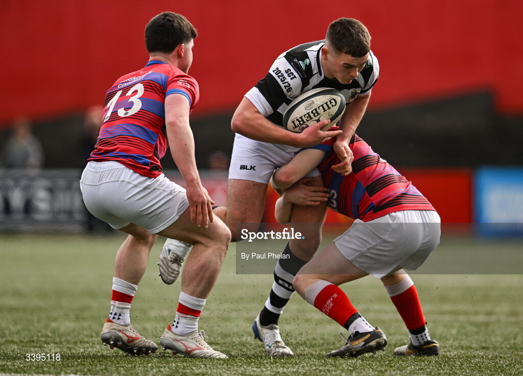 18 March 2026; Fionn O'Sullivan of Presentation Brothers College is tackled by Brendan Minogue and Thomas O'Brien of St. Munchin’s College during the Pinergy Munster Schools Boys Senior Cup final match between Presentation Brothers College, Cork and St. Munchin’s College, Limerick at Virgin Media Park in Cork. Photo by Paul Phelan/Sportsfile