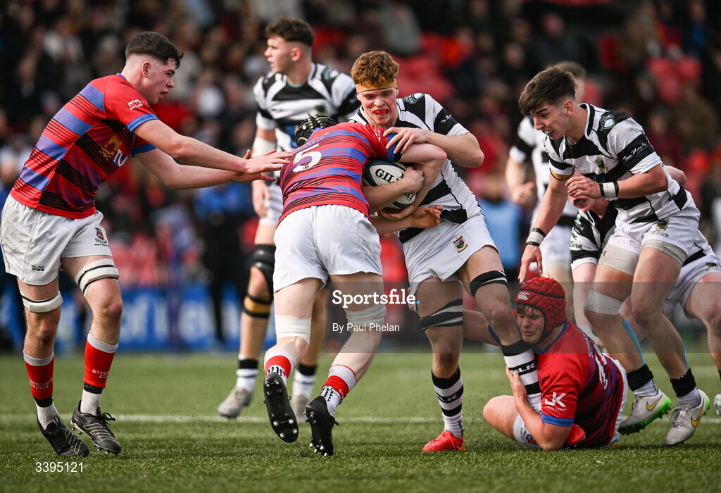 18 March 2026; Rian MacFarlane O'Shea of Presentation Brothers College is tackled by Cillian McGrath and Oisin Gleeson of St. Munchin’s College during the Pinergy Munster Schools Boys Senior Cup final match between Presentation Brothers College, Cork and St. Munchin’s College, Limerick at Virgin Media Park in Cork. Photo by Paul Phelan/Sportsfile