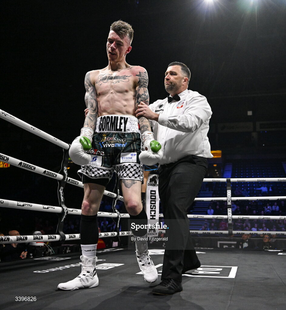 20 March 2026; Lee Gormley is led away by referee Eamonn Magill after the fight against Codie Smith was stopped during their super featherweight bout at the SSE Arena in Belfast. Photo by David Fitzgerald/Sportsfile